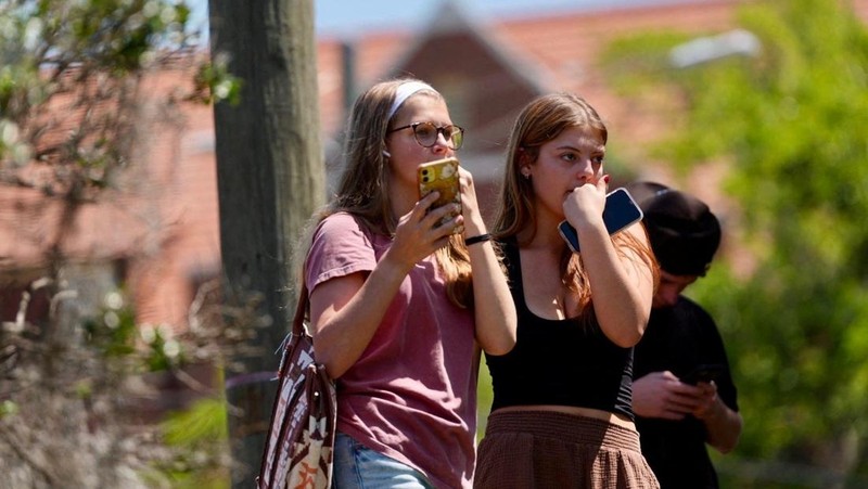 Orang-orang berkumpul saat dievakuasi oleh petugas polisi menyusul tanggapan terhadap laporan penembakan di Universitas Negeri Florida, di Tallahassee, Florida, AS, 17 April 2025, dalam tangkapan layar yang diperoleh dari video media sosial. (@ignqiny via X/via REUTERS)