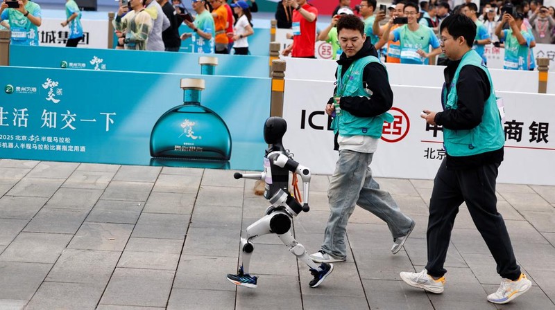 Para teknisi berlari bersama robot humanoid 