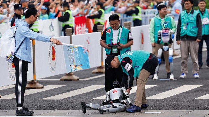 Para teknisi berlari bersama robot humanoid 