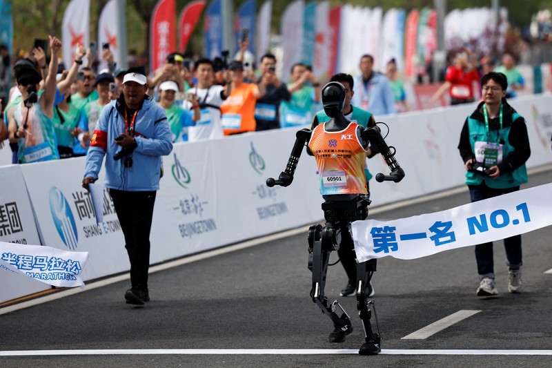 Para teknisi berlari bersama robot humanoid Para teknisi berlari bersama robot humanoid