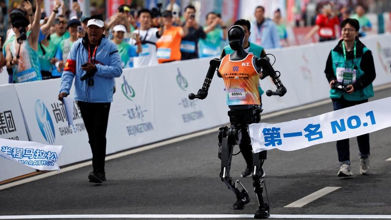 Para teknisi berlari bersama robot humanoid 