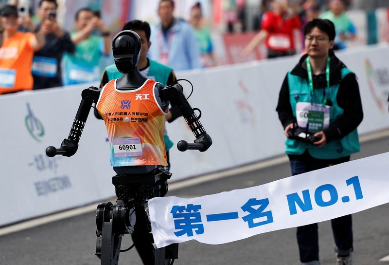 Para teknisi berlari bersama robot humanoid Para teknisi berlari bersama robot humanoid