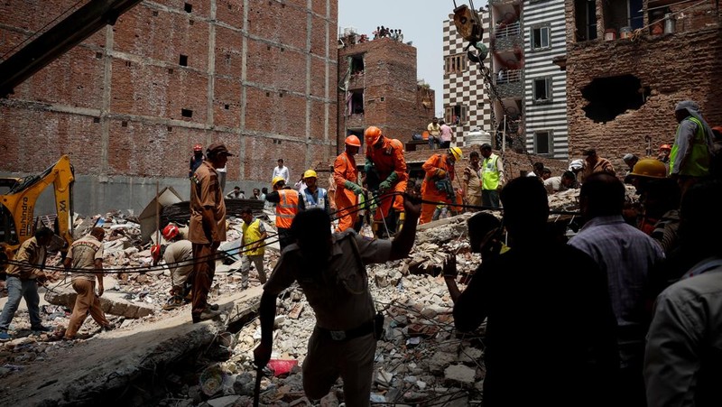 Petugas darurat menggunakan derek untuk memindahkan lempengan di lokasi bangunan runtuh di New Delhi, India, 19 April 2025. (REUTERS/Adnan Abidi)