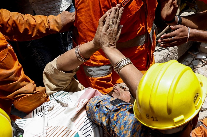 Petugas darurat menggunakan derek untuk memindahkan lempengan di lokasi bangunan runtuh di New Delhi, India, 19 April 2025. Petugas darurat menggunakan derek untuk memindahkan lempengan di lokasi bangunan runtuh di New Delhi, India, 19 April 2025. (REUTERS/Adnan Abidi)