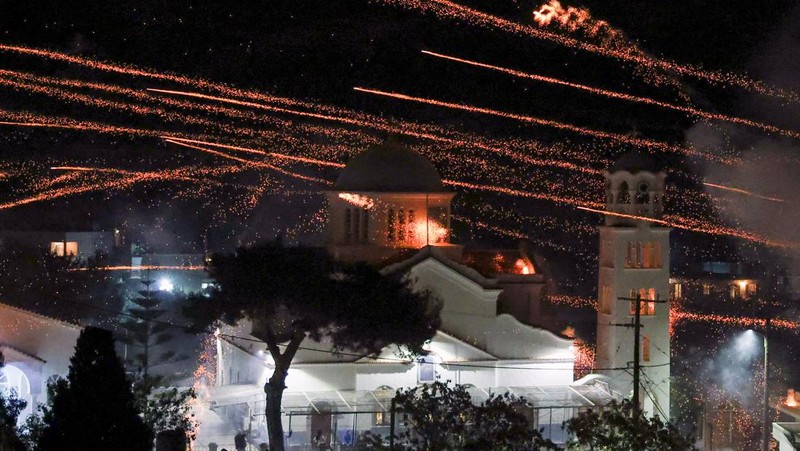 Roket buatan tangan terbang di atas gereja Panagia Erithiani selama perayaan Paskah Ortodoks Yunani di desa Vrontados, di pulau Chios, Yunani, 19 April 2025. (REUTERS/Konstantinos Anagnostou)
