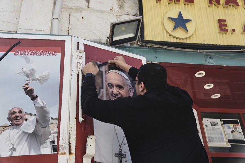 A pilgrim carries a cross near St Peter's square, after the death of Pope Francis was announced by the Vatican, as seen from Rome, Italy, April 21, 2025. REUTERS/Guglielmo Mangiapane