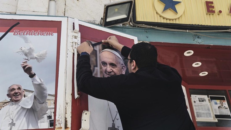 A pilgrim carries a cross near St Peter's square, after the death of Pope Francis was announced by the Vatican, as seen from Rome, Italy, April 21, 2025. REUTERS/Guglielmo Mangiapane