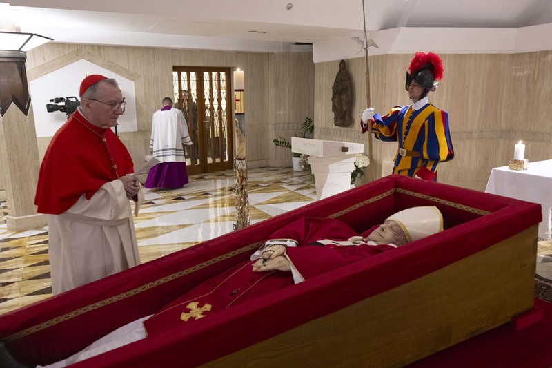 Jenazah Paus Fransiskus ditempatkan dalam peti jenazah terbuka selama ritual pernyataan kematian di kediaman Santa Marta di Vatikan, 22 April 2025. (Vatican Media via AP, HO)