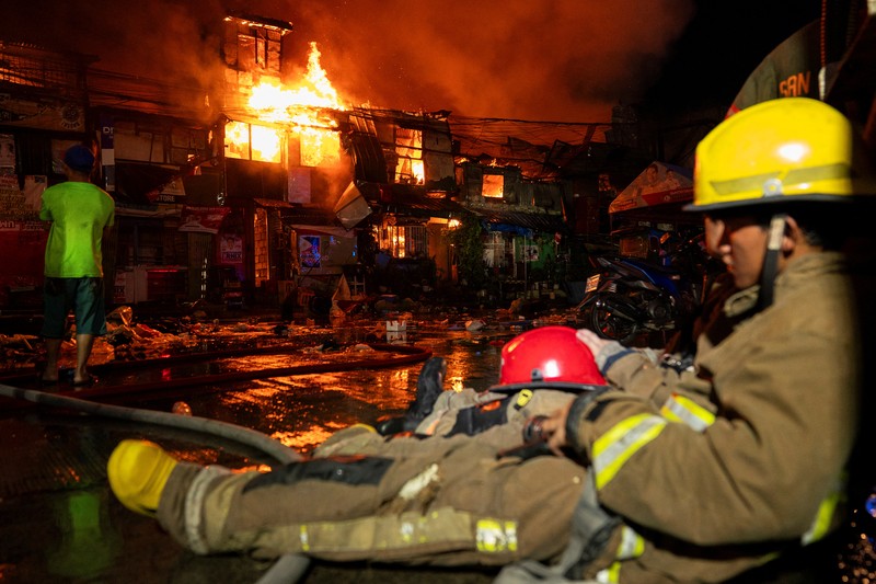 Petugas pemadam kebakaran bekerja memadamkan kebakaran di kawasan pemukiman di Manila, Filipina, 23 April 2025. Petugas pemadam kebakaran bekerja memadamkan kebakaran di kawasan pemukiman di Manila, Filipina, 23 April 2025. (REUTERS/Lisa Marie David)