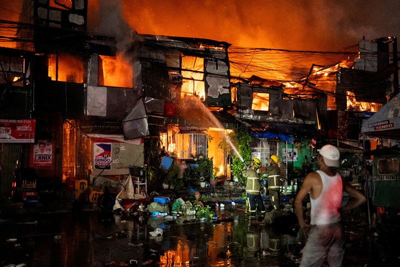Petugas pemadam kebakaran bekerja memadamkan kebakaran di kawasan pemukiman di Manila, Filipina, 23 April 2025. Petugas pemadam kebakaran bekerja memadamkan kebakaran di kawasan pemukiman di Manila, Filipina, 23 April 2025. (REUTERS/Lisa Marie David)