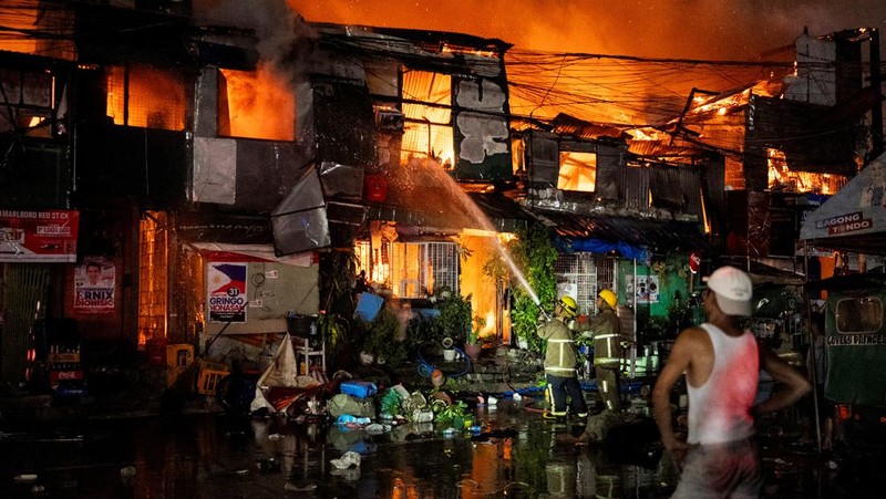 Petugas pemadam kebakaran bekerja memadamkan kebakaran di kawasan pemukiman di Manila, Filipina, 23 April 2025. (REUTERS/Lisa Marie David)