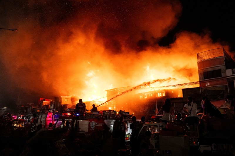 Petugas pemadam kebakaran bekerja memadamkan kebakaran di kawasan pemukiman di Manila, Filipina, 23 April 2025. (REUTERS/Lisa Marie David)