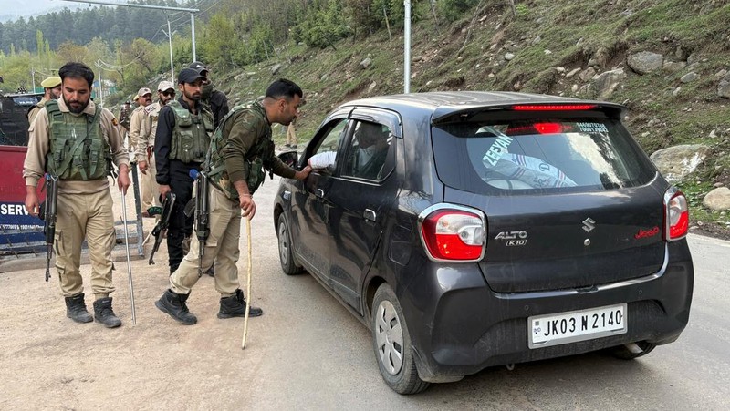 Petugas polisi India menghentikan kendaraan di pos pemeriksaan menyusul dugaan serangan militan, di Pahalgam di distrik Anantnag, Kashmir selatan, 22 April 2025. (REUTERS/Stringer)