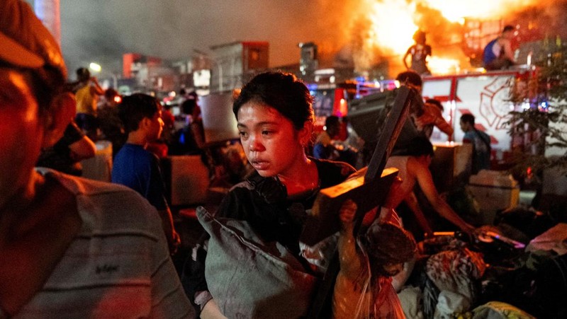 Petugas pemadam kebakaran bekerja memadamkan kebakaran di kawasan pemukiman di Manila, Filipina, 23 April 2025. (REUTERS/Lisa Marie David)