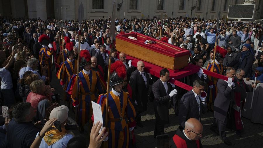 The body of Pope Francis is carried into St. Peter's Basilica at the Vatican, Wednesday, April 23, 2025, where he will lie in state for three days. (AP Photo/Emilio Morenatti)