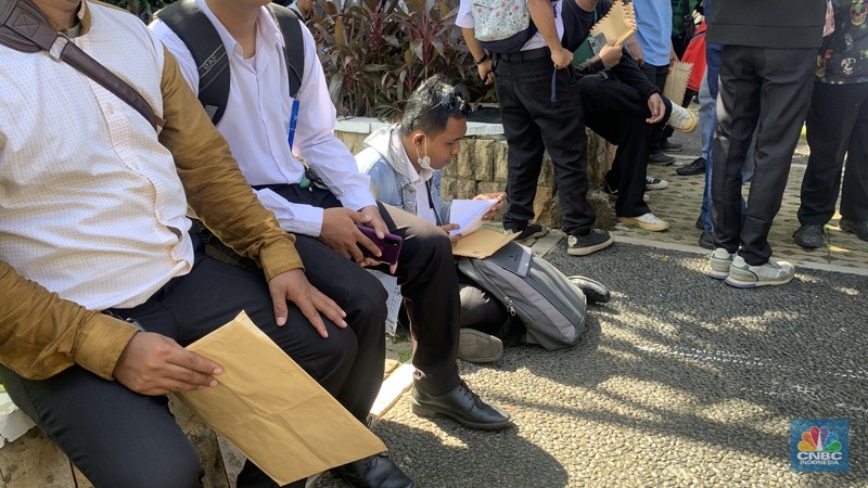 Warga DKI Jakarta memadati Balai Kota pada Rabu (23/4/2025) untuk melamar kerja sebagai PPSU, petugas damkar, kebersihan, hingga lingkungan. Mereka mengantre sejak pagi sambil membawa berkas lamaran sebagian bahkan mengisi formulir di trotoar dan taman sekitar lokasi. (CNBC Indonesia/Fergi Nadira)