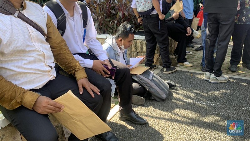 Warga DKI Jakarta memadati Balai Kota pada Rabu (23/4/2025) untuk melamar kerja sebagai PPSU, petugas damkar, kebersihan, hingga lingkungan. Mereka mengantre sejak pagi sambil membawa berkas lamaran sebagian bahkan mengisi formulir di trotoar dan taman sekitar lokasi. (CNBC Indonesia/Fergi Nadira)