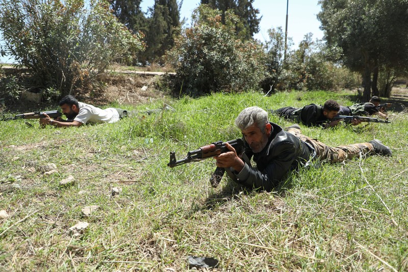 Wanita dan pria Kurdi menghadiri pelatihan tentang cara menggunakan senjata di Qamishli, Suriah, 12 April 2025. (REUTERS/Orhan Qereman)