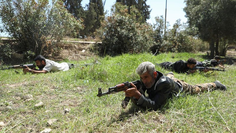 Wanita dan pria Kurdi menghadiri pelatihan tentang cara menggunakan senjata di Qamishli, Suriah, 12 April 2025. (REUTERS/Orhan Qereman)