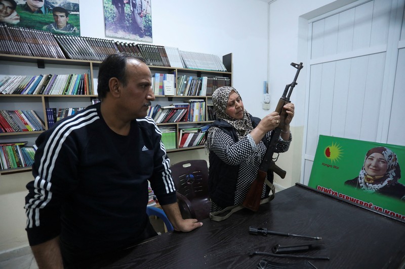 Wanita dan pria Kurdi menghadiri pelatihan tentang cara menggunakan senjata di Qamishli, Suriah, 12 April 2025. (REUTERS/Orhan Qereman)