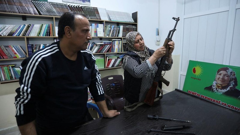 Wanita dan pria Kurdi menghadiri pelatihan tentang cara menggunakan senjata di Qamishli, Suriah, 12 April 2025. (REUTERS/Orhan Qereman)