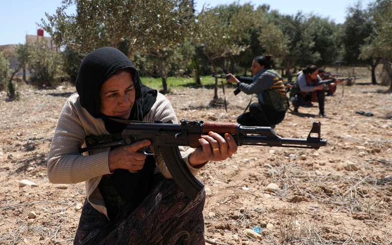 Wanita dan pria Kurdi menghadiri pelatihan tentang cara menggunakan senjata di Qamishli, Suriah, 12 April 2025. (REUTERS/Orhan Qereman)