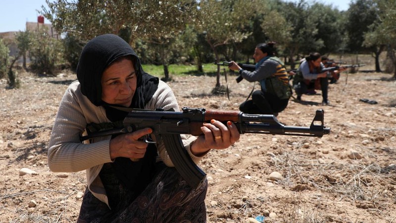 Wanita dan pria Kurdi menghadiri pelatihan tentang cara menggunakan senjata di Qamishli, Suriah, 12 April 2025. (REUTERS/Orhan Qereman)