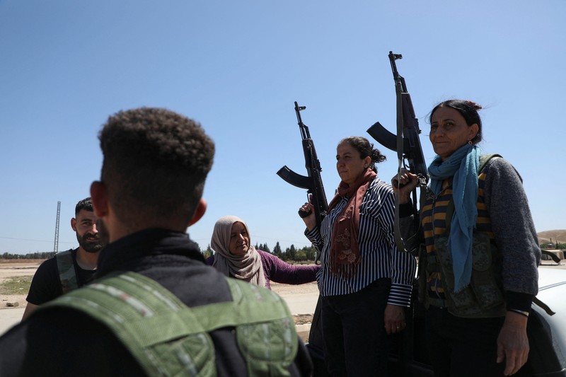 Wanita dan pria Kurdi menghadiri pelatihan tentang cara menggunakan senjata di Qamishli, Suriah, 12 April 2025. (REUTERS/Orhan Qereman)