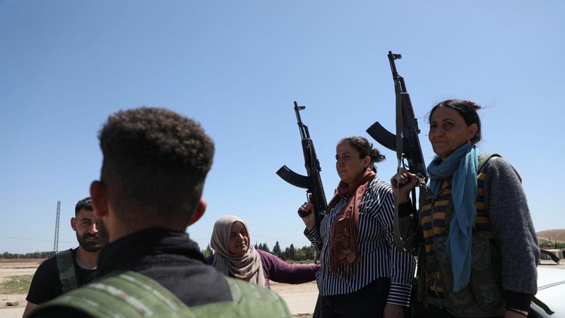 Wanita dan pria Kurdi menghadiri pelatihan tentang cara menggunakan senjata di Qamishli, Suriah, 12 April 2025. (REUTERS/Orhan Qereman)
