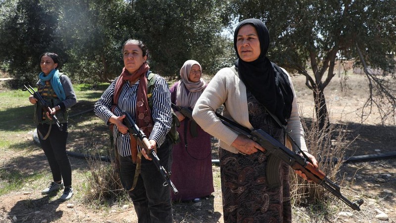 Wanita dan pria Kurdi menghadiri pelatihan tentang cara menggunakan senjata di Qamishli, Suriah, 12 April 2025. (REUTERS/Orhan Qereman)