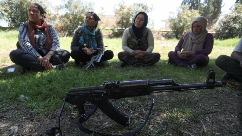 Wanita dan pria Kurdi menghadiri pelatihan tentang cara menggunakan senjata di Qamishli, Suriah, 12 April 2025. (REUTERS/Orhan Qereman)