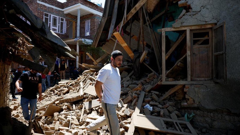 Seorang pria berdiri di depan rumah keluarga Adil Thoker yang dihancurkan oleh otoritas India di desa Guri di Anantnag, Kashmir selatan, 25 April 2025. (REUTERS/Adnan Abidi)
