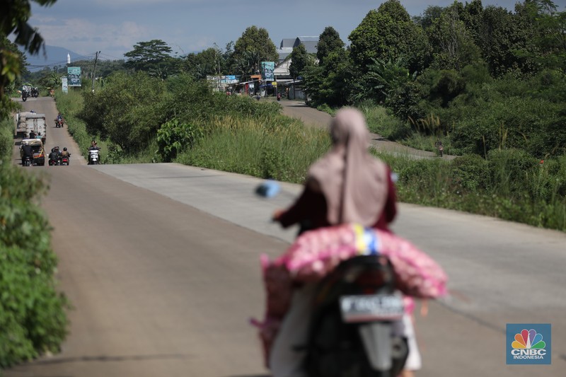 Pengendara melewati jalan Bojonggede-Kemang (Bomang) yang belum selesai pengerjaannya di kawasan Tajur Halang, Kabupaten Bogor, Jawa Barat, Jumat (25/4/2025). (CNBC Indonesia/Tri Susilo)