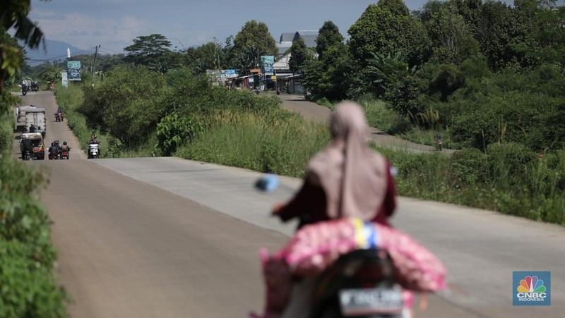 Pengendara melewati jalan Bojonggede-Kemang (Bomang) yang belum selesai pengerjaannya di kawasan Tajur Halang, Kabupaten Bogor, Jawa Barat, Jumat (25/4/2025). (CNBC Indonesia/Tri Susilo)
