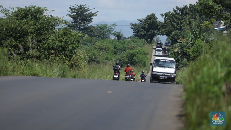 Pengendara melewati jalan Bojonggede-Kemang (Bomang) yang belum selesai pengerjaannya di kawasan Tajur Halang, Kabupaten Bogor, Jawa Barat, Jumat (25/4/2025). (CNBC Indonesia/Tri Susilo)