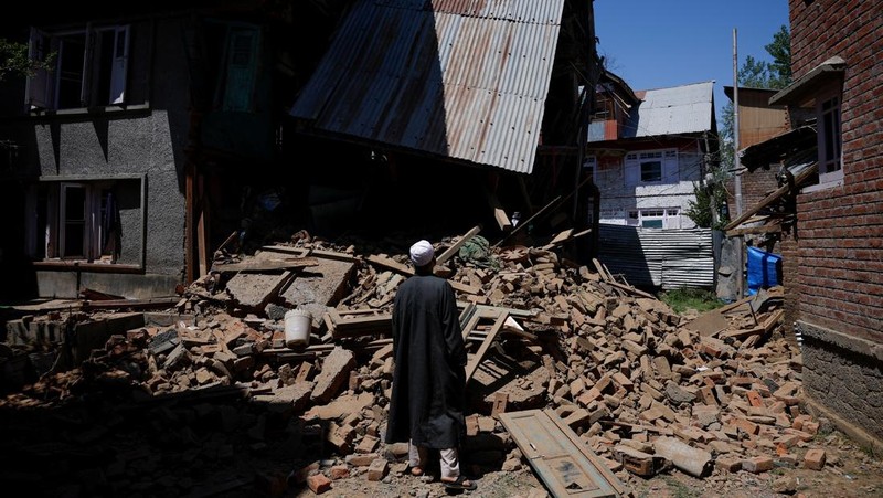 Seorang pria berdiri di depan rumah keluarga Adil Thoker yang dihancurkan oleh otoritas India di desa Guri di Anantnag, Kashmir selatan, 25 April 2025. (REUTERS/Adnan Abidi)