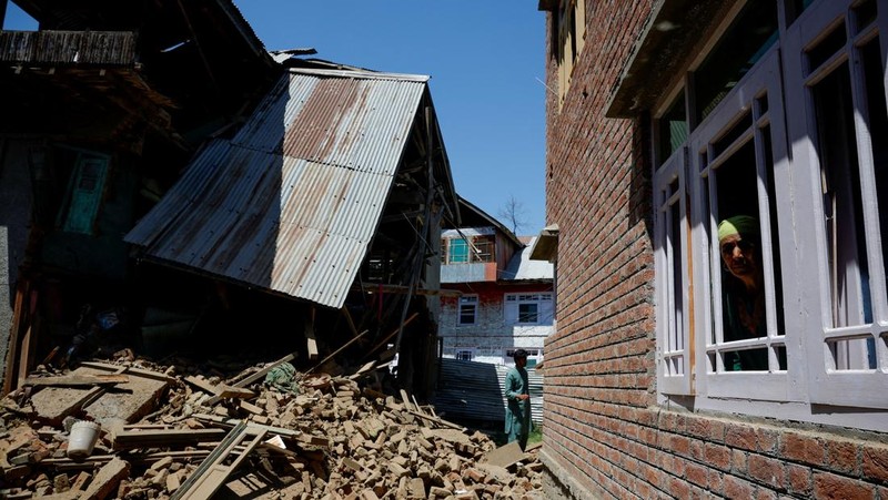 Seorang pria berdiri di depan rumah keluarga Adil Thoker yang dihancurkan oleh otoritas India di desa Guri di Anantnag, Kashmir selatan, 25 April 2025. (REUTERS/Adnan Abidi)