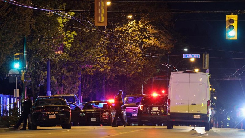 Petugas polisi bekerja di tempat kejadian perkara, sementara jasad korban tergeletak di tanah, setelah sebuah kendaraan melaju ke arah kerumunan saat pesta blok Lapu Lapu di Vancouver, Kanada, Sabtu (26/4/2025). (REUTERS/Chris Helgren)