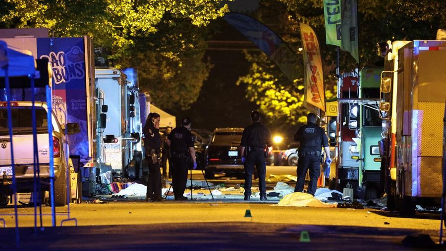 Petugas polisi bekerja di tempat kejadian perkara, sementara jasad korban tergeletak di tanah, setelah sebuah kendaraan melaju ke arah kerumunan saat pesta blok Lapu Lapu di Vancouver, Kanada, Sabtu (26/4/2025). (REUTERS/Chris Helgren)