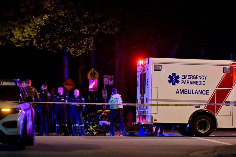 Petugas polisi bekerja di tempat kejadian perkara, sementara jasad korban tergeletak di tanah, setelah sebuah kendaraan melaju ke arah kerumunan saat pesta blok Lapu Lapu di Vancouver, Kanada, Sabtu (26/4/2025). (REUTERS/Chris Helgren)