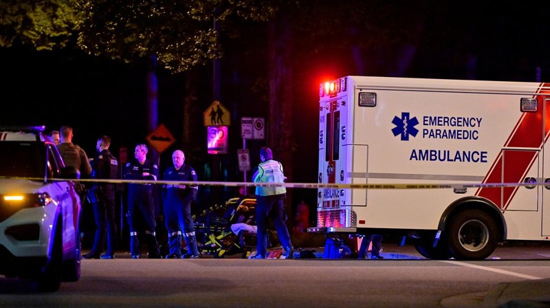 Petugas polisi bekerja di tempat kejadian perkara, sementara jasad korban tergeletak di tanah, setelah sebuah kendaraan melaju ke arah kerumunan saat pesta blok Lapu Lapu di Vancouver, Kanada, Sabtu (26/4/2025). (REUTERS/Chris Helgren)