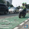 Pengendara motor melintas di jalur sepeda Jalan Jenderal Sudirman, Jakarta, Selasa (29/4/2025). Gubernur DKI Jakarta Pramono Anung akan menertibkan jalur sepeda seiring adanya korban kecelakaan hingga meninggal dunia akibat kendaraan yang berhenti di