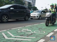 Pengendara motor melintas di jalur sepeda Jalan Jenderal Sudirman, Jakarta, Selasa (29/4/2025). Gubernur DKI Jakarta Pramono Anung akan menertibkan jalur sepeda seiring adanya korban kecelakaan hingga meninggal dunia akibat kendaraan yang berhenti di