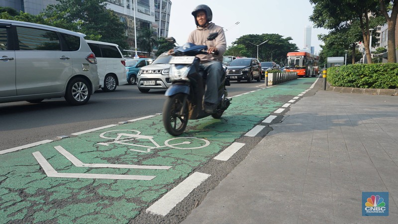 Pengendara motor melintas di jalur sepeda Jalan Jenderal Sudirman, Jakarta, Selasa (29/4/2025). Gubernur DKI Jakarta Pramono Anung akan menertibkan jalur sepeda seiring adanya korban kecelakaan hingga meninggal dunia akibat kendaraan yang berhenti di jalur sepeda, serta akan membangun jalur sepeda tambahan sepanjang 3,8 kilometer. (CNBC Indonesia/Muhammad Sabki)