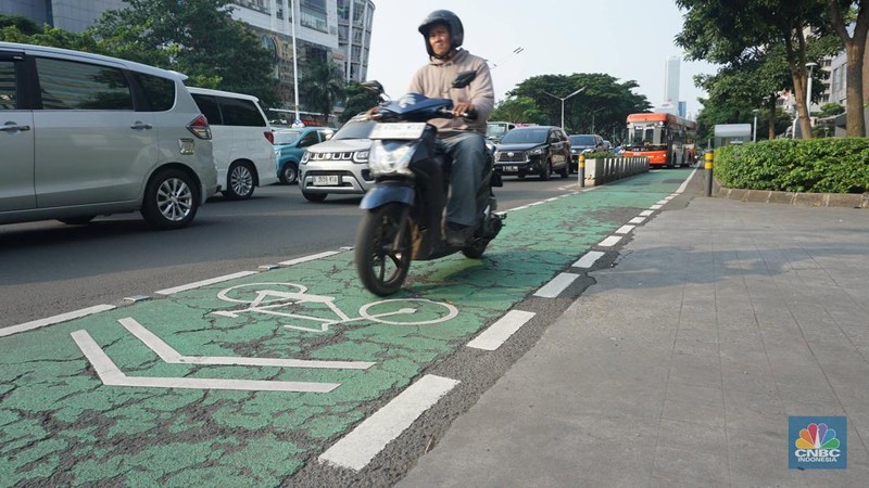 Pengendara motor melintas di jalur sepeda Jalan Jenderal Sudirman, Jakarta, Selasa (29/4/2025). Gubernur DKI Jakarta Pramono Anung akan menertibkan jalur sepeda seiring adanya korban kecelakaan hingga meninggal dunia akibat kendaraan yang berhenti di jalur sepeda, serta akan membangun jalur sepeda tambahan sepanjang 3,8 kilometer. (CNBC Indonesia/Muhammad Sabki)