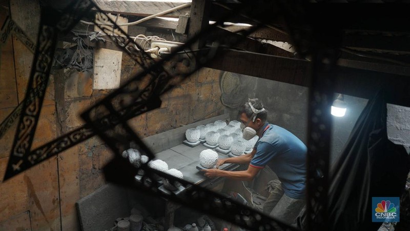 Perajin usaha kecil dan menengah (UKM) mengecat cenderamata berbahan resin di kawasan Makasar, Jakarta Timur, Selasa (29/4/2025). (CNBC Indonesia/Muhammad Sabki)