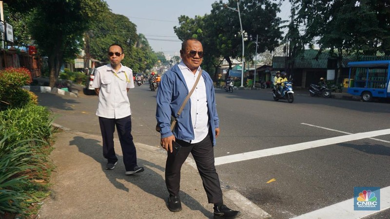 Sejumlah Aparatur Sipil Negara (ASN) berjalan usai naik transportasi umum di kawasan Balai Kota, Jakarta Pusat, pada Rabu (30/4/2025). (CNBC Indonesia/Muhammad Sabki)