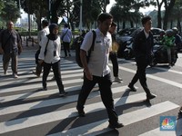 Sejumlah Aparatur Sipil Negara (ASN) berjalan usai naik transportasi umum di kawasan Balai Kota, Jakarta Pusat, pada Rabu (30/4/2025). (CNBC Indonesia/Muhammad Sabki)