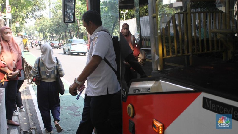 Sejumlah Aparatur Sipil Negara (ASN) berjalan usai naik transportasi umum di kawasan Balai Kota, Jakarta Pusat, pada Rabu (30/4/2025). (CNBC Indonesia/Muhammad Sabki)