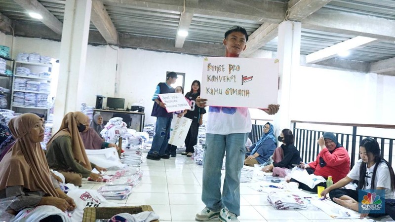 Sejumlah selebgram membawa tulisan penyemangat bagi pekerja dan pelaku IKM (Industri Kecil Menengah) di industri konveksi rumahan Sinergi Adv Nusantara, Jakarta, Rabu (30/4/2025). (վ/Muhammad Sabki)